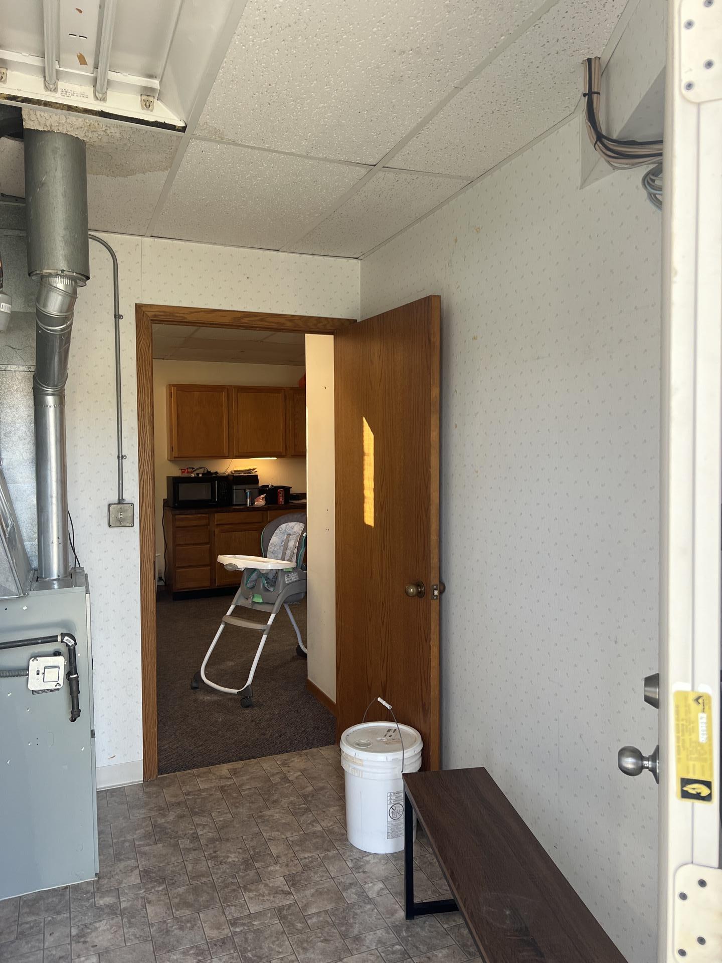 An entryway leading to a kitchen, showcasing interior details and utility elements, potentially part of a property assessment or during a restoration project by Alpha Omega Restoration Pros.