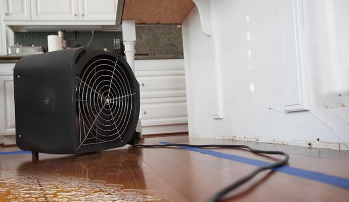 Water damage restoration dryer equipment placed on wooden floor